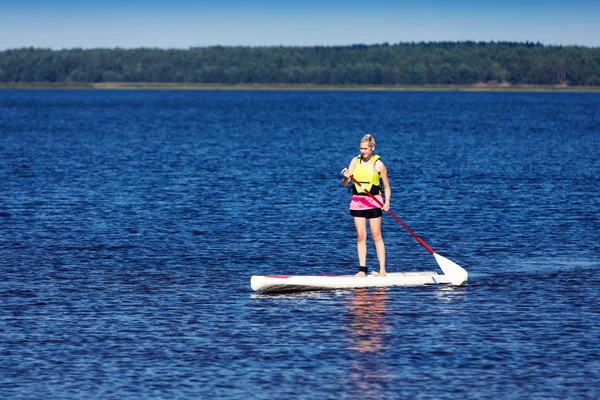 Sup - mulher em pé prancha de remo no lago — Fotografia de Stock