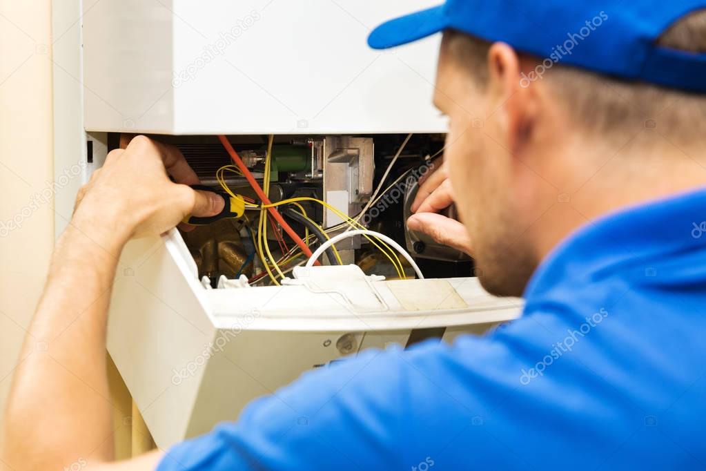 maintenance service engineer working with home gas heating boiler