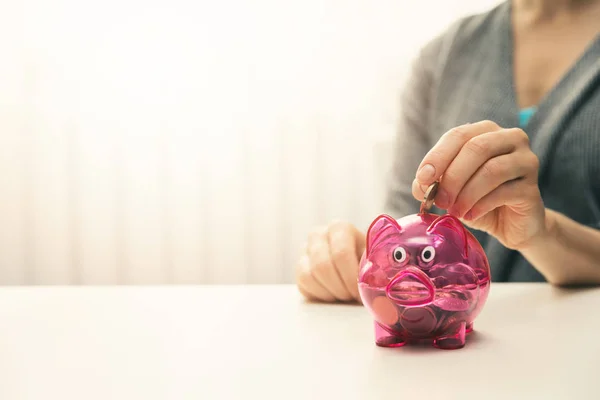 Woman putting coin in piggy bank. copy space — Stock Photo, Image