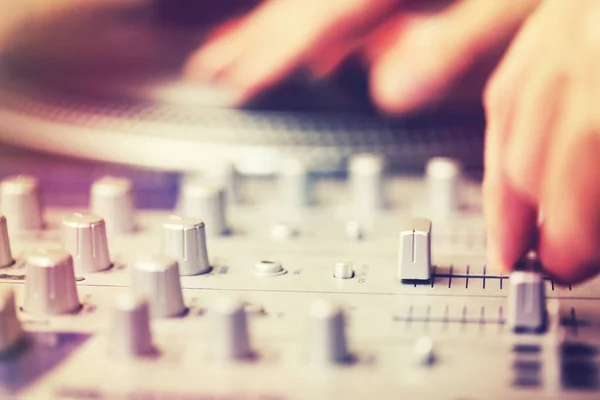 DJ krabben en mixen van muziek op een feest in club — Stockfoto