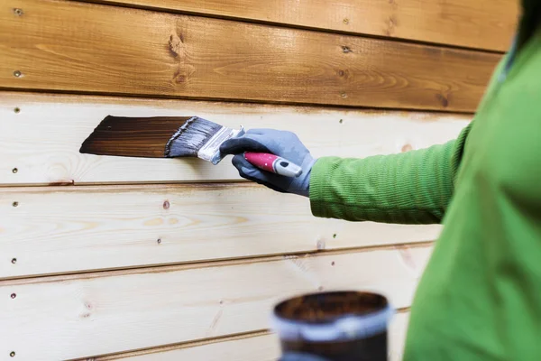 Schilder met penseel schilderen gevel met hout beschermende kleur — Stockfoto