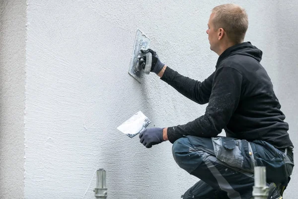 Trabajador de la construcción poniendo yeso decorativo en el exterior de la casa — Foto de Stock