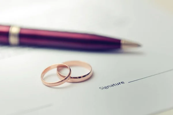 Marriage contract - wedding rings on agreement — Stock Photo, Image