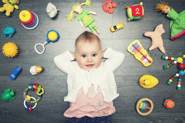 Mignonne petite fille avec beaucoup de jouets sur le sol. vue de dessus — Photo