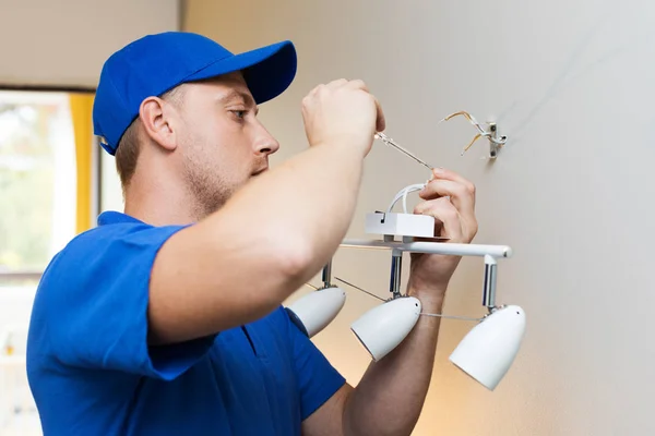 Eletricista no trabalho - instalação de lâmpada na parede — Fotografia de Stock