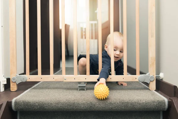 Enfant jouant derrière les barrières de sécurité devant les escaliers à la maison — Photo