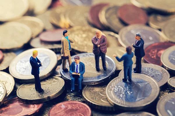 Grupo de empresários em pé na pilha de dinheiro do euro e falando — Fotografia de Stock