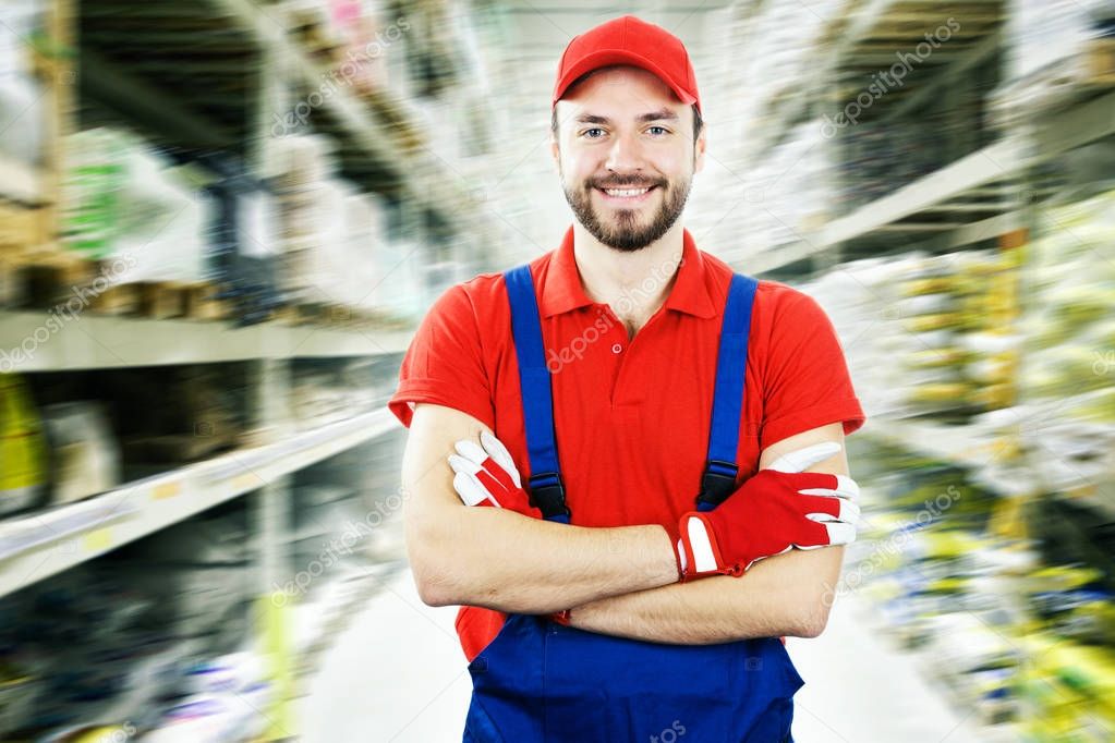 smiling warehouse worker standing between shelves
