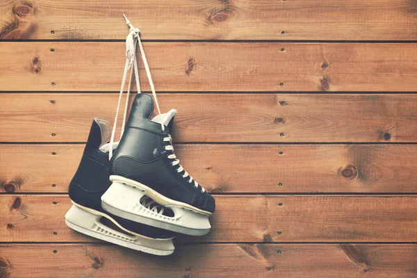 Eishockey-Schlittschuhe hängen am Nagel auf Holzplanke Hintergrund — Stockfoto