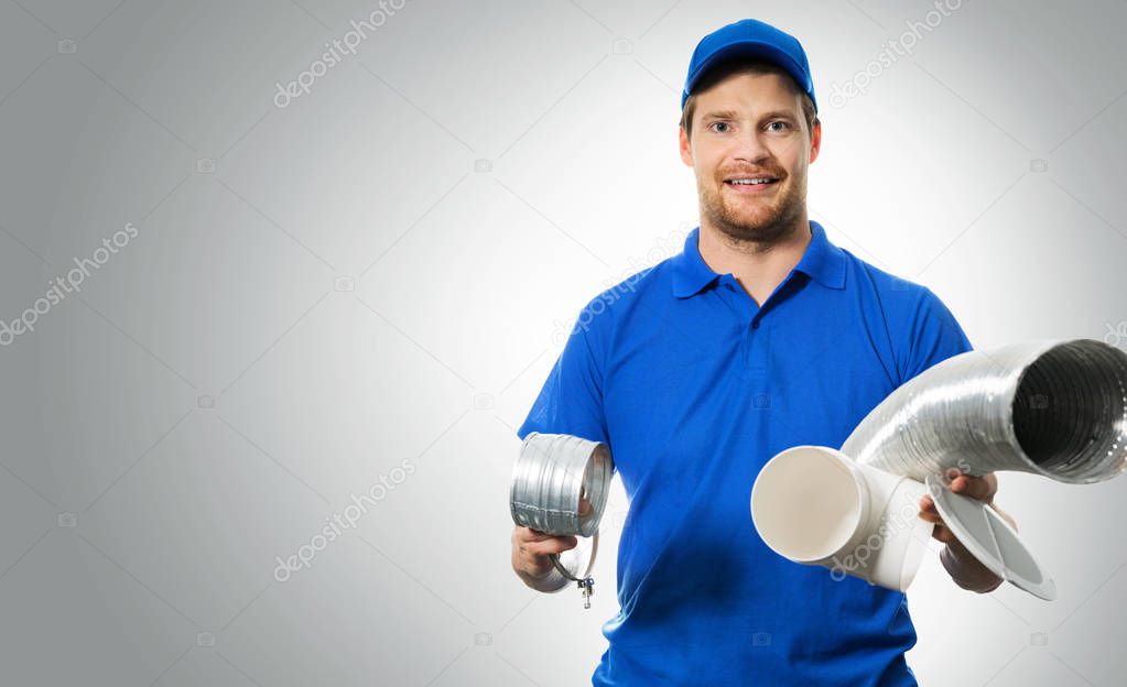 hvac worker with ventilation system equipment in hands on gray background
