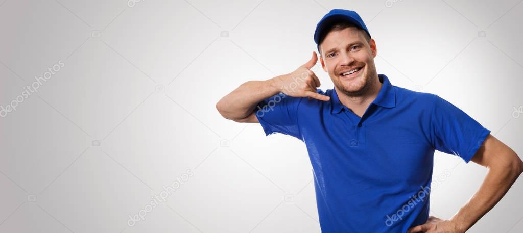 worker in blue uniform making phone call gesture