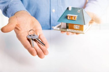 Emlakçı ile ev modeli ve anahtarları elinde