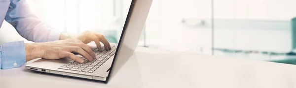 Homme d'affaires moderne tapant sur clavier d'ordinateur portable dans un bureau ensoleillé lumineux. copyspace — Photo