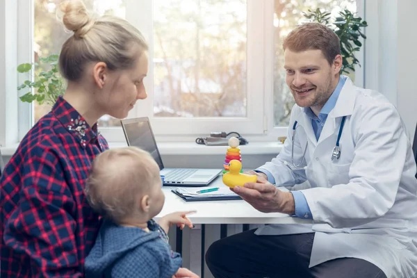 Médecin donne à l'enfant un jouet de canard lors d'une visite médicale — Photo