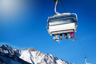 kayakçı Kayak Merkezi mavi güneşli gökyüzüne karşı bir telesiyej içinde