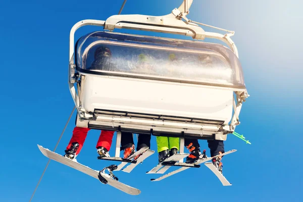 People in a chairlift at ski resort on sunny winter day — Stock Photo, Image