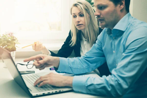 Férfi és nő együtt dolgoznak a hivatalban. valamit megvitatni a laptop — Stock Fotó