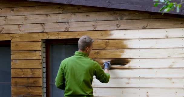 Målare Med Pensel Målning Hus Fasad Med Trä Skyddande Färg — Stockvideo