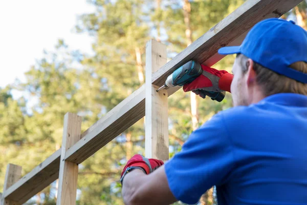 Bouwvakker bezig met houten huis structuur — Stockfoto