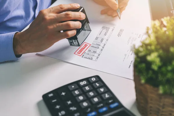 Homme d'affaires acceptant et estampillant la facture d'achat au bureau — Photo