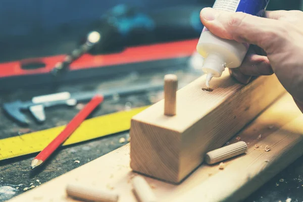 Carpintería de muebles - carpintero poner pegamento en un agujero perforado para la madera — Foto de Stock