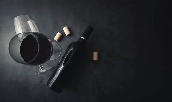 Red wine bottle and glass on black stone background with copy sp — Stock Photo, Image