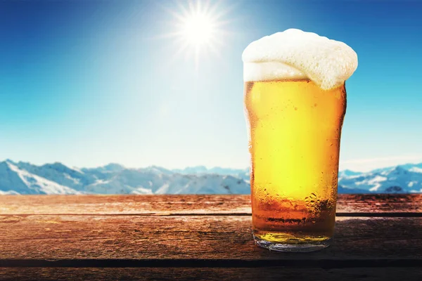 햇빛 이 잘 드는 겨울 산악 지대 가 스키 리조트에 있는 탁자 위에는 아이스하키식 맥주 잔이 놓여 있습니다. 복사 공간 — 스톡 사진