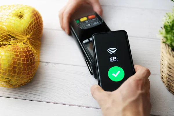 Nfc contactless payment with phone at groceries store — Stock Photo, Image
