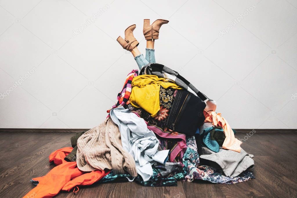 woman legs out of a pile of clothes on the floor. shopping addic