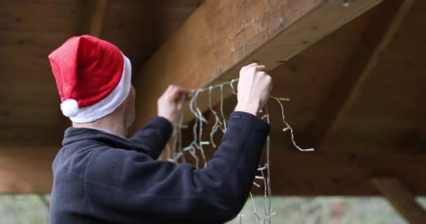 Człowiek Santa Kapelusz Dekorowanie Domu Zewnątrz Carport Christmas Strunowe Światła — Wideo stockowe