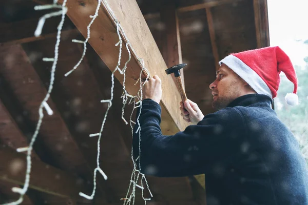 Άνδρας με καπέλο santa διακόσμηση σπίτι εξωτερικό carport με christm — Φωτογραφία Αρχείου