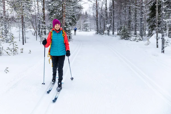 Esqui cross country - mulher com esquis na pista de esqui da floresta nevada — Fotografia de Stock