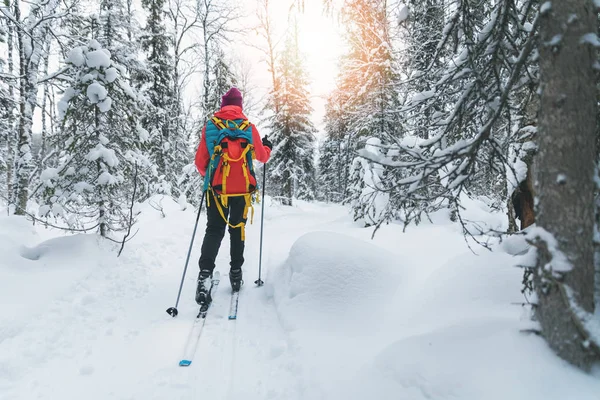 Ski touring - kvinna med skidor på en snöig vinter skogsstig. - Ja då. — Stockfoto