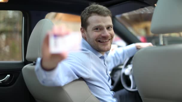 Ung Glad Man Sitter Bilen Och Visar Sitt Nya Körkort — Stockvideo