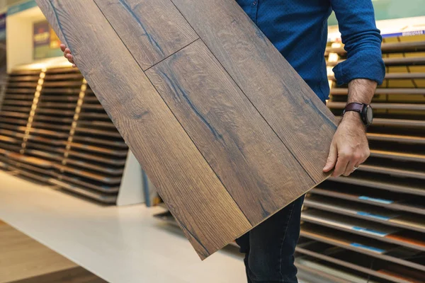 Padlóburkolat eladó laminált padlóburkolat minta panel a kezében — Stock Fotó