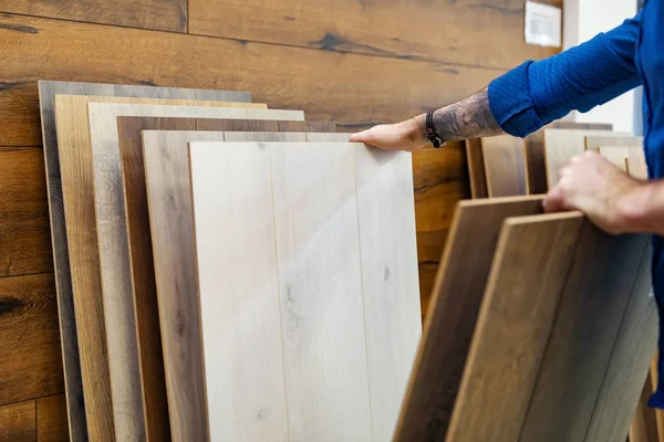 Mann wählt Bodenlaminat für sein Haus im Fußbodengeschäft — Stockfoto