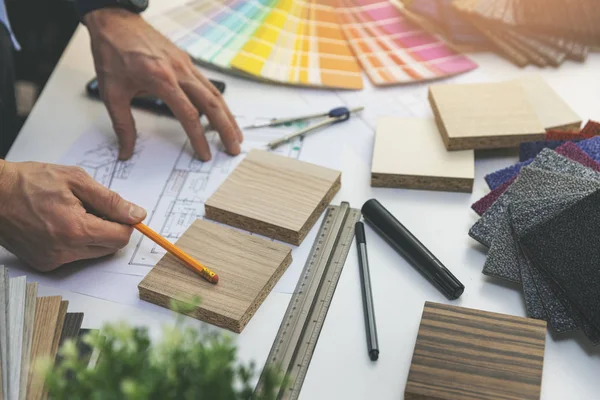 Designer choosing flooring and furniture materials from samples — Stock Photo, Image