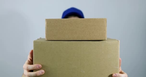 Delivery Man Holding Pile Cardboard Boxes Front Gray Background — Stock Video