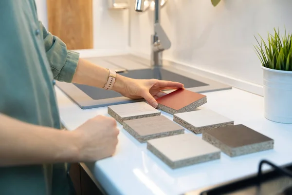 Frau wählt Küchenarbeitsplatte Material Textur aus Proben — Stockfoto