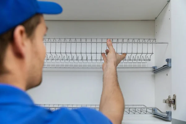 Meubelservice medewerker installeren keuken kast schotel rek — Stockfoto