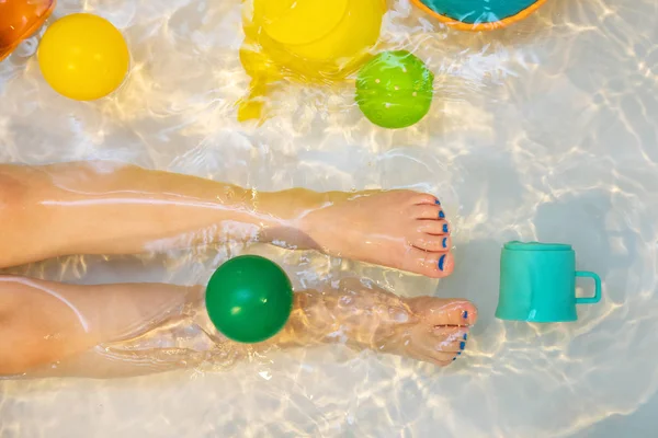 Child legs with toys in the bath. top view — Stock Photo, Image
