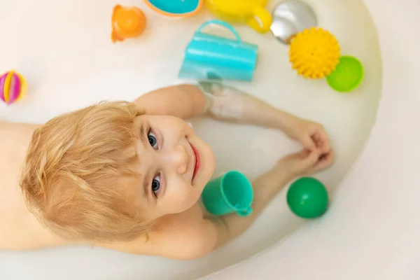 Enfant heureux prendre un bain et jouer avec des jouets. vue de dessus — Photo