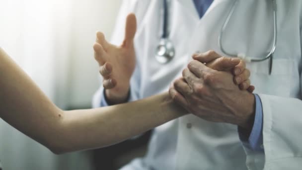 Arts Praten Diagnose Terwijl Het Houden Van Patiënt Hand Kliniek — Stockvideo