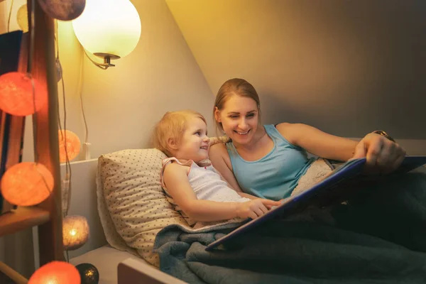 Madre e hija leyendo libro de hadas cola juntos en el par —  Fotos de Stock