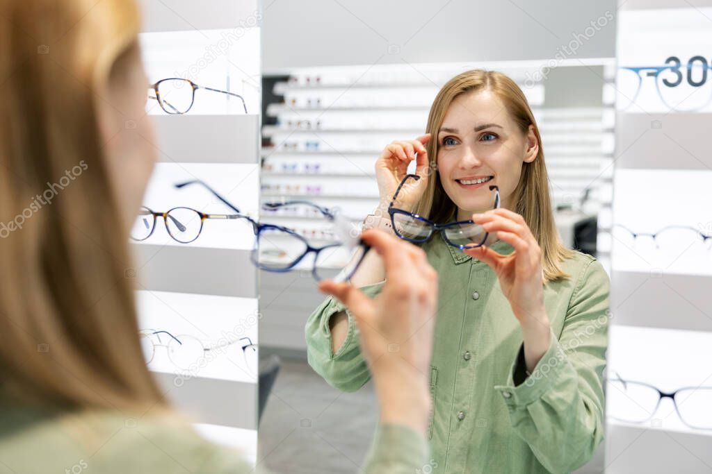 woman trying on optical glasses in eyewear store