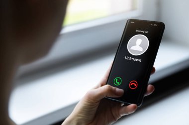 Bilinmeyen numaradan aranan cep telefonlu bir kadın.