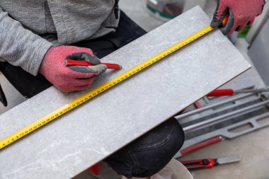 İşçi seramik taşları kalem ve mezura ile işaretliyor.