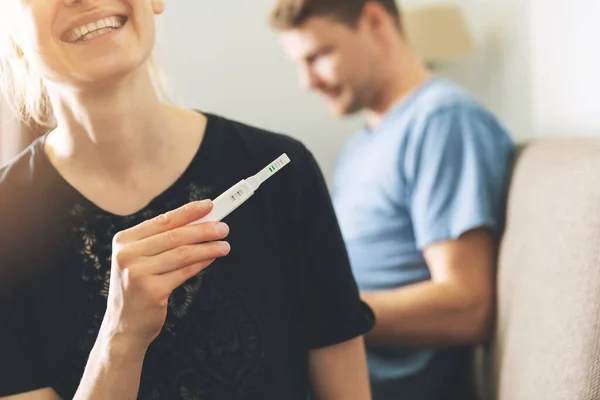 Jovem Mulher Feliz Sentado Sofá Casa Segurando Teste Gravidez Positivo — Fotografia de Stock