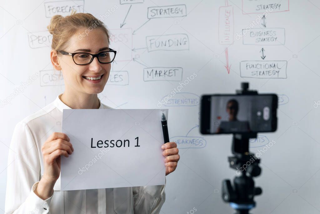 online education, webinar and business vlog concept - woman teaching and recording video with phone in front of whiteboard