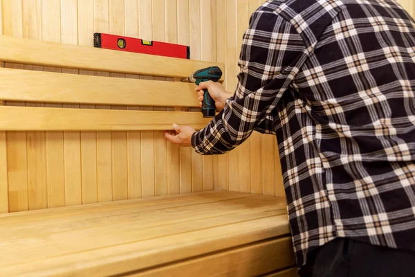 Sauna Construction Man Screwing Wooden Bench Backrest Wall — Stock Photo, Image